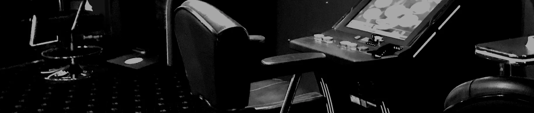 Blick in die Spielhalle: Geldspielgeräte mit Sitzplätzen, schwarzweiß.